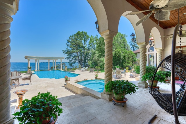 view of swimming pool featuring an in ground hot tub, a patio area, ceiling fan, and a water view