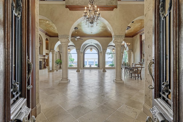 foyer featuring tile flooring, crown molding, and decorative columns