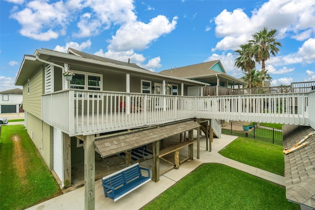 rear view of property with a deck, a patio area, and a yard