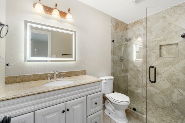 bathroom featuring a shower with door, vanity, and toilet