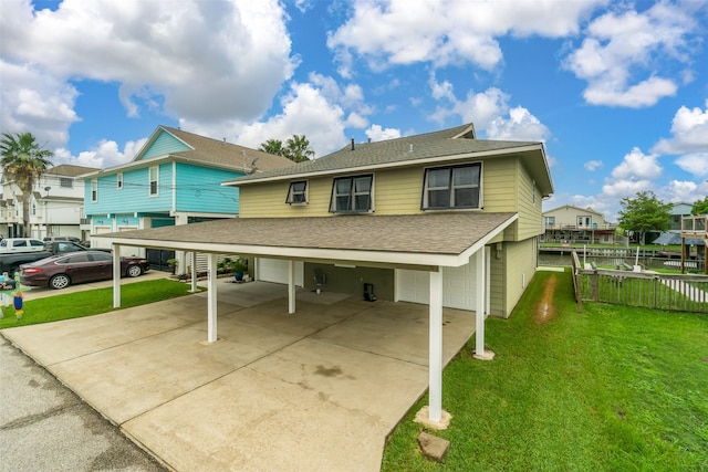 view of front of house featuring a garage, a carport, and a front lawn