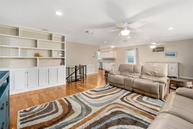 living room featuring ceiling fan and light hardwood / wood-style flooring