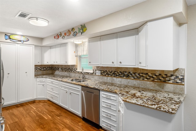 kitchen with dishwasher, wood-type flooring, white cabinetry, and tasteful backsplash