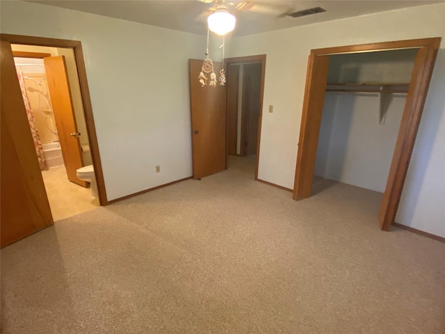 unfurnished bedroom with light carpet, ensuite bath, a closet, and ceiling fan