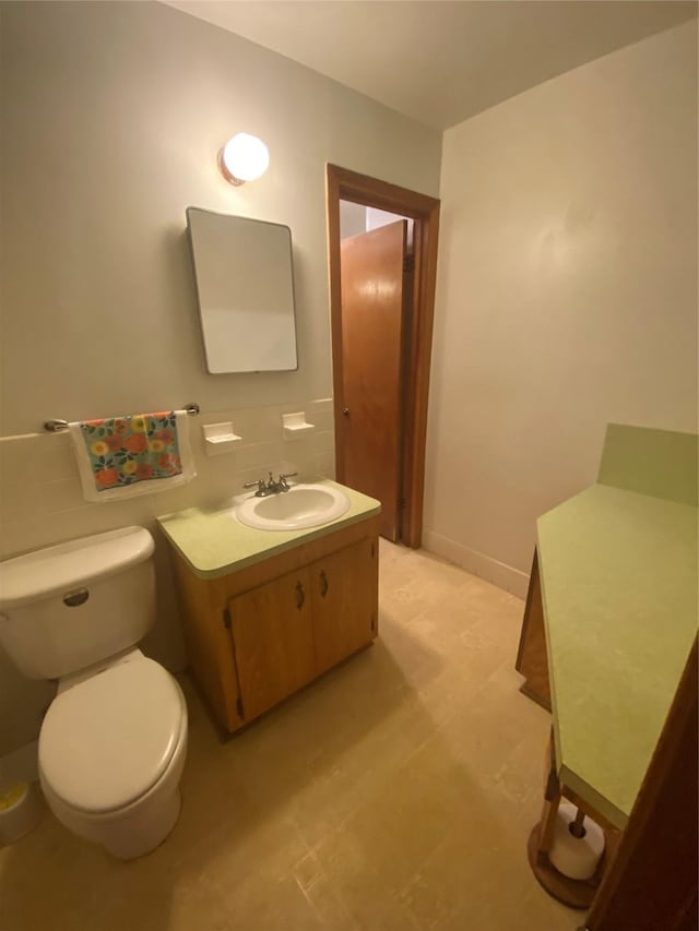 bathroom with decorative backsplash, vanity, and toilet