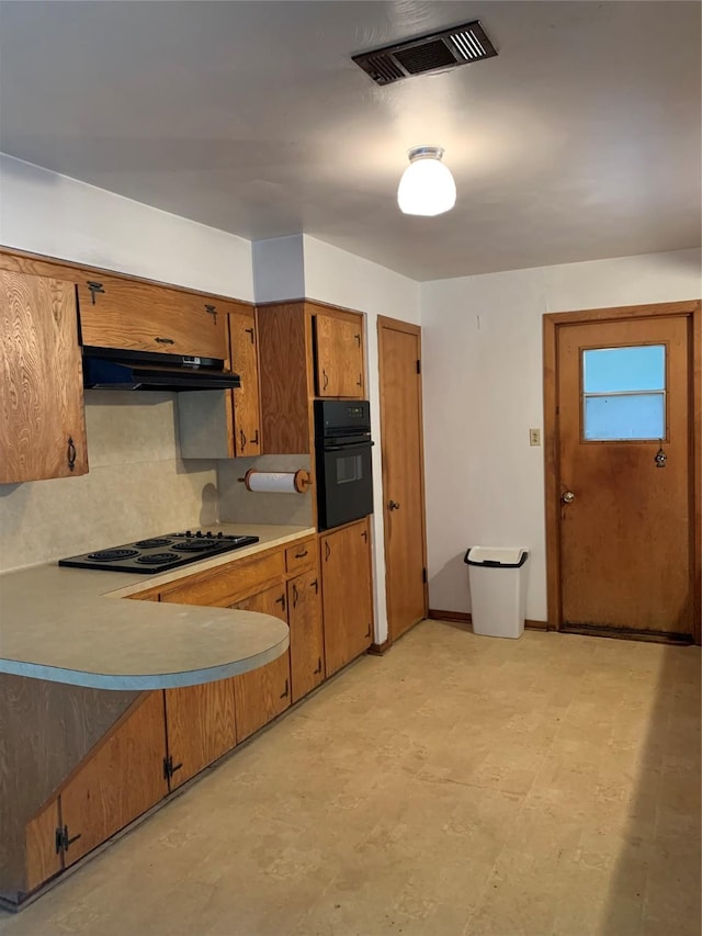 kitchen featuring cooktop, decorative backsplash, and oven