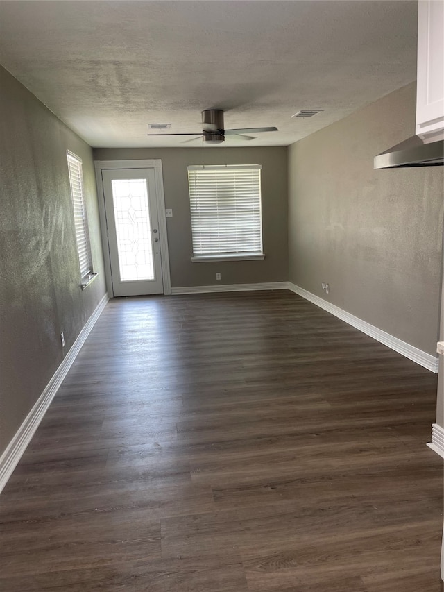 empty room with dark wood-type flooring and ceiling fan