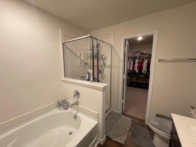 full bathroom with shower with separate bathtub, vanity, toilet, and hardwood / wood-style floors