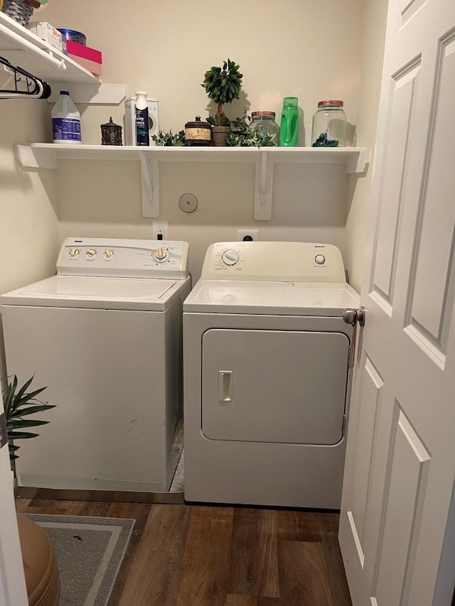 clothes washing area with washer and dryer and dark wood-type flooring