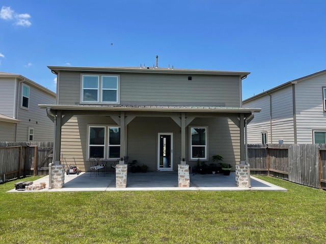 rear view of house featuring a lawn and a patio