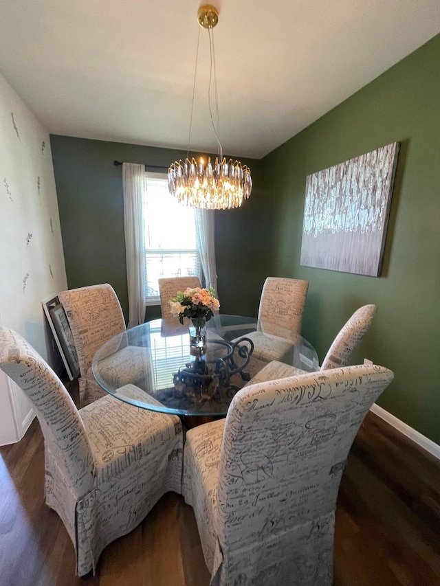 dining space with dark hardwood / wood-style flooring and a chandelier