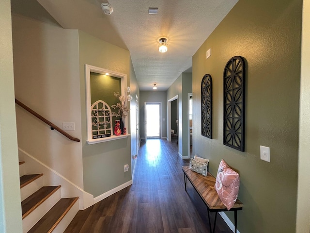 hall with dark hardwood / wood-style flooring and a textured ceiling