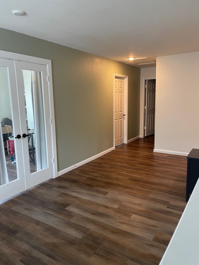 spare room featuring dark hardwood / wood-style flooring and french doors