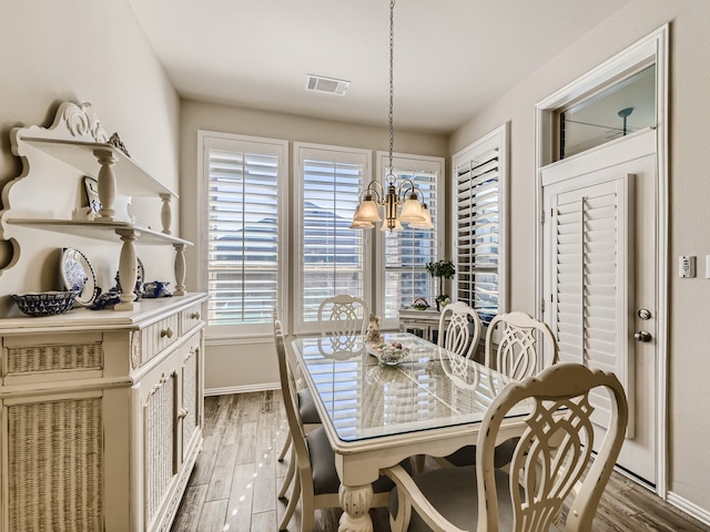 dining space featuring a chandelier, hardwood / wood-style flooring, and a healthy amount of sunlight