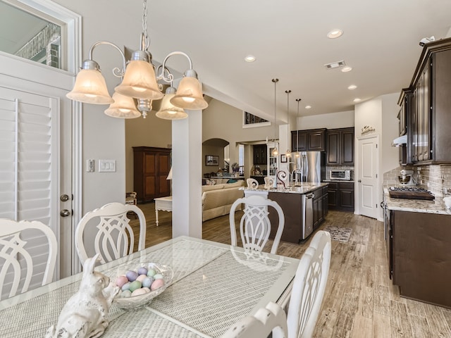 dining room with light hardwood / wood-style flooring and an inviting chandelier