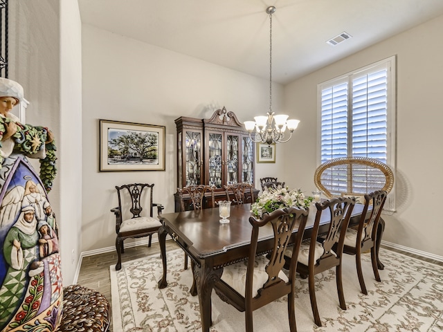 dining area with a chandelier and light hardwood / wood-style flooring