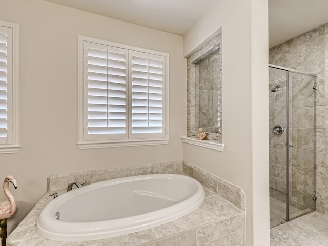 bathroom featuring separate shower and tub