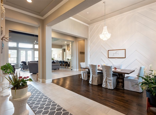 dining space featuring hardwood / wood-style floors, a notable chandelier, ornamental molding, and french doors