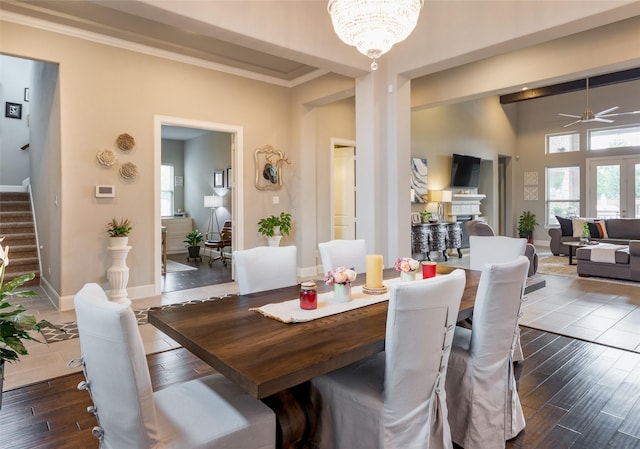 dining area featuring hardwood / wood-style flooring, ceiling fan with notable chandelier, and crown molding