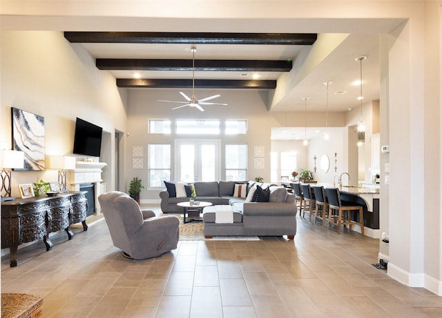 living room with ceiling fan and beamed ceiling