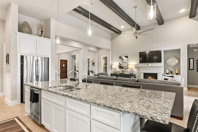 kitchen featuring beam ceiling, sink, white cabinets, and pendant lighting