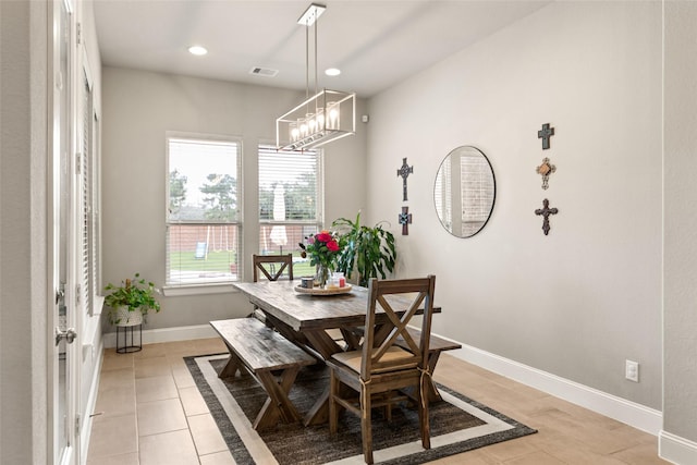 dining area with plenty of natural light, light tile patterned flooring, and a chandelier