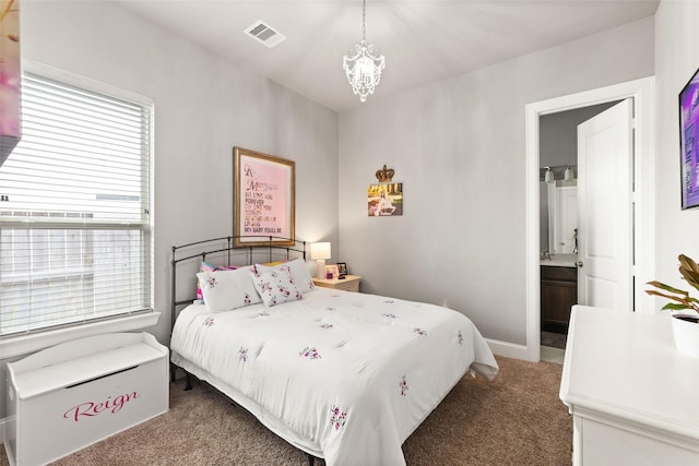 bedroom featuring carpet flooring, multiple windows, connected bathroom, and an inviting chandelier