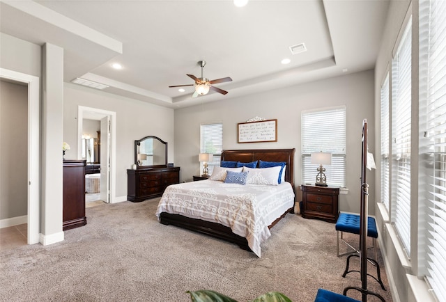 carpeted bedroom featuring a raised ceiling and ceiling fan