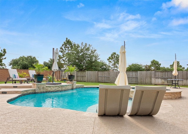 view of swimming pool with pool water feature and a patio