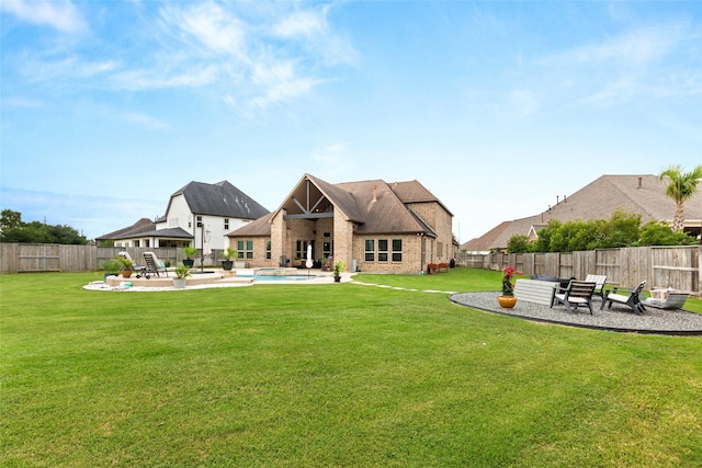 rear view of house featuring a patio, a fenced in pool, and a lawn