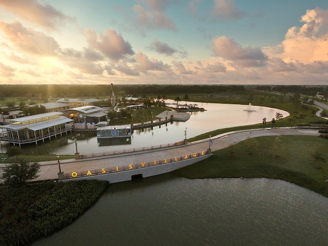 aerial view at dusk featuring a water view