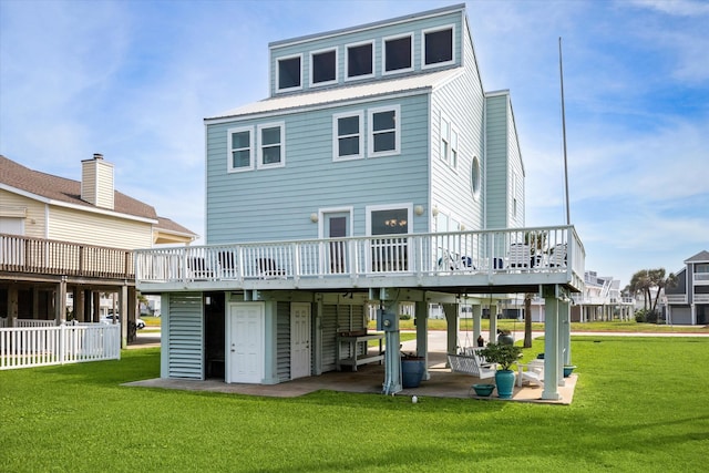 rear view of property with a patio, a wooden deck, and a yard