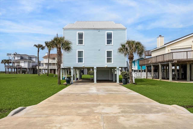 rear view of property featuring a carport and a yard