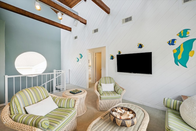 living room featuring beam ceiling, high vaulted ceiling, and carpet flooring