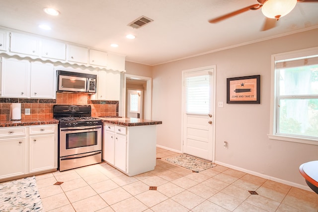 kitchen with backsplash, appliances with stainless steel finishes, white cabinetry, and light tile floors