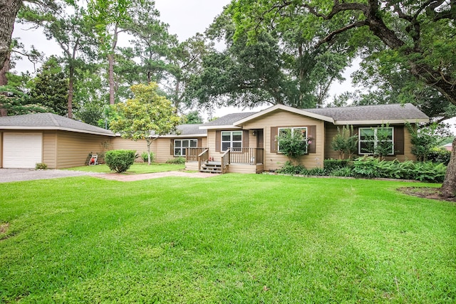 single story home featuring a deck, a front lawn, and a garage