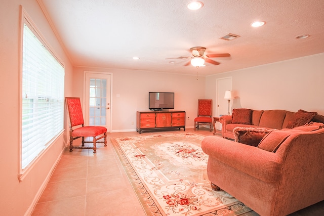 tiled living room with a textured ceiling, plenty of natural light, and ceiling fan