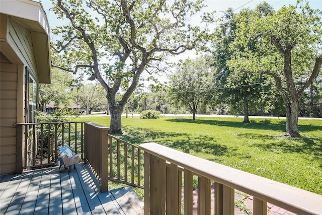 wooden deck featuring a lawn