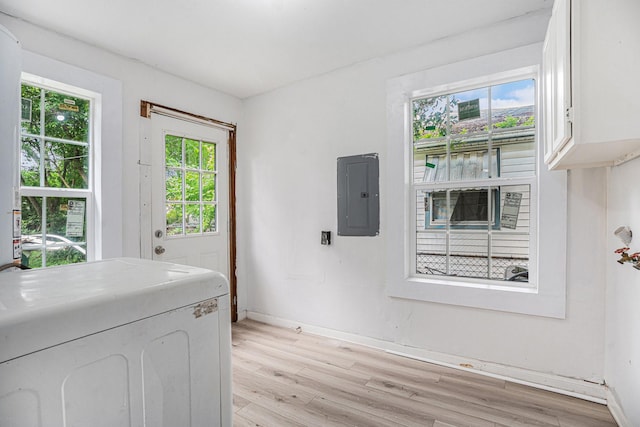 clothes washing area with washer / dryer, light wood-type flooring, and electric panel