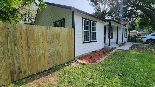 view of home's exterior with a porch and a yard