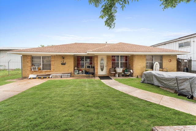 ranch-style house featuring cooling unit and a front lawn