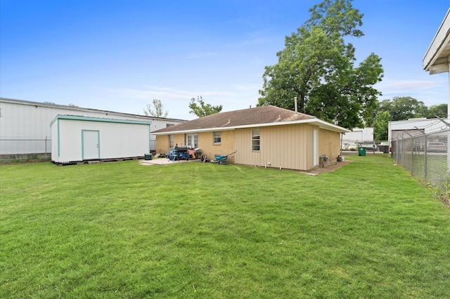 rear view of house with a lawn and a storage shed