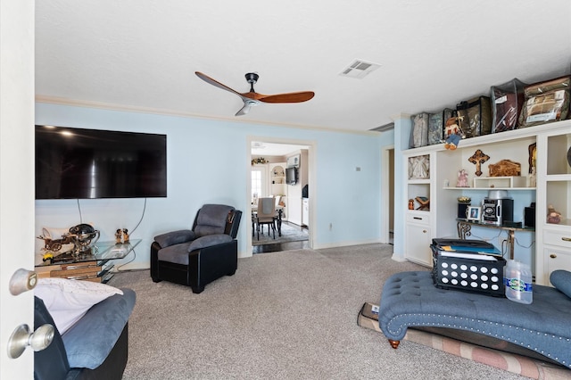 living room featuring carpet, ceiling fan, and ornamental molding