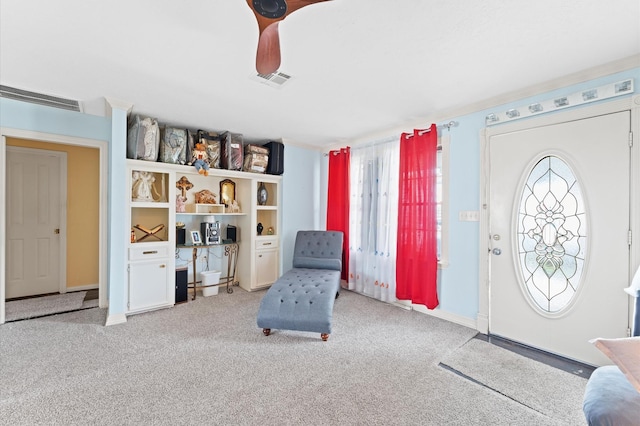 sitting room with ceiling fan and light colored carpet