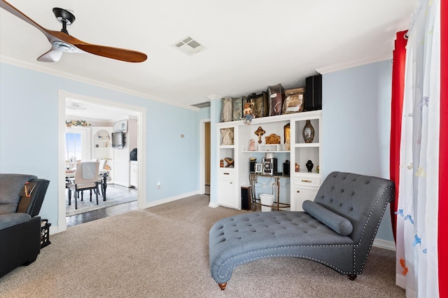 living area with carpet flooring, ceiling fan, and ornamental molding