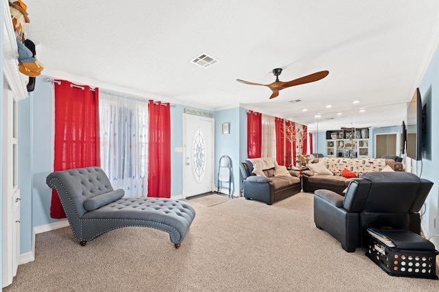 carpeted living room featuring ceiling fan and ornamental molding