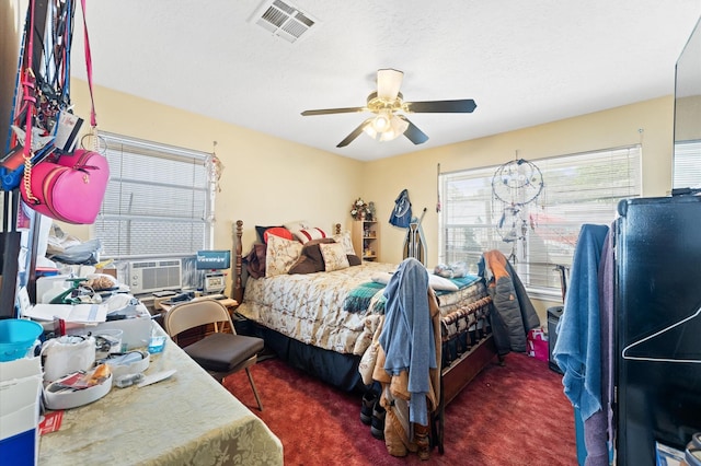 bedroom with ceiling fan, a textured ceiling, and dark colored carpet