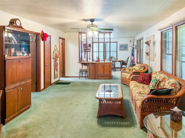 living room with a healthy amount of sunlight, a textured ceiling, ceiling fan, and carpet flooring