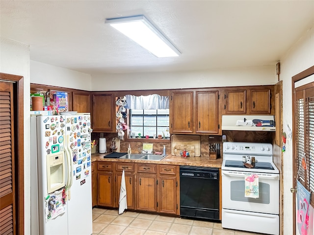 kitchen featuring sink, light tile patterned flooring, backsplash, and white appliances