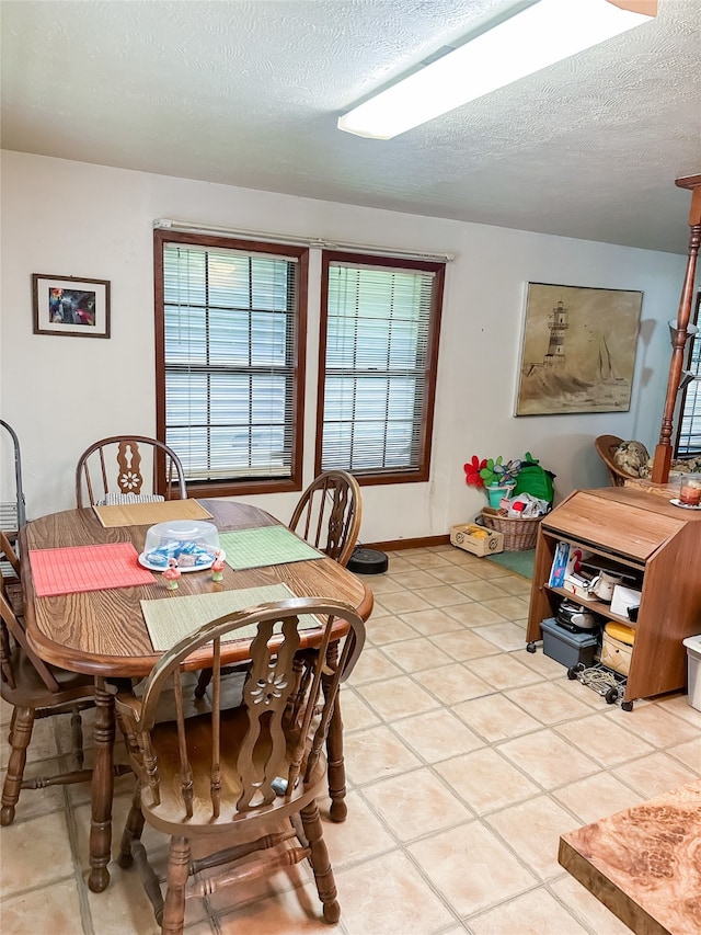 dining area featuring a textured ceiling, a healthy amount of sunlight, and light tile patterned floors